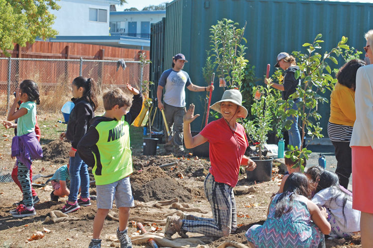 children and adults gardening in a community garden